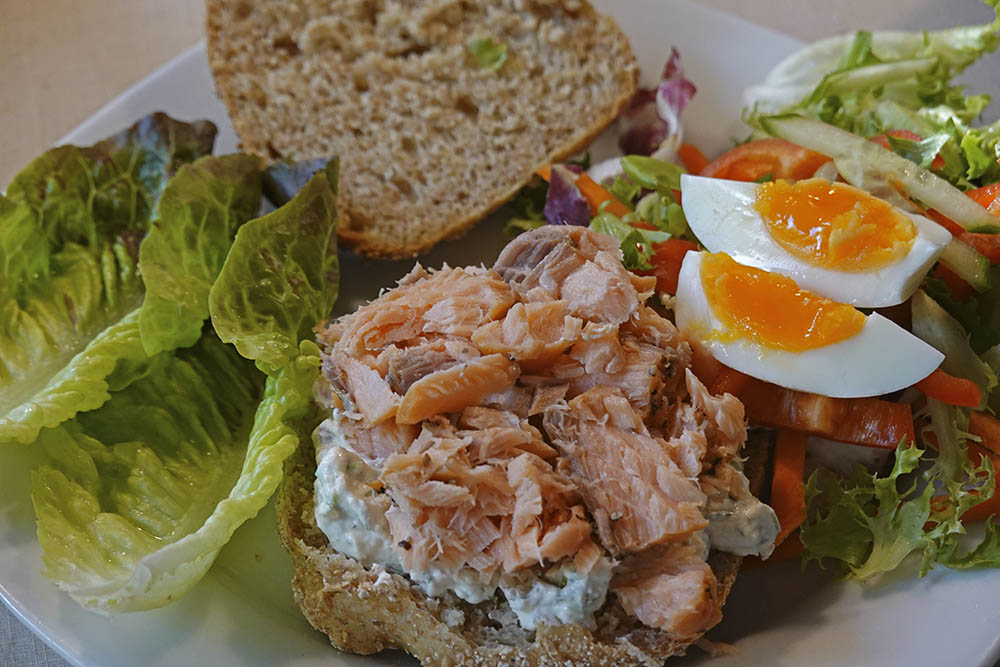 Grovbolle med rygeostcreme, varmrget laks og bindsalat